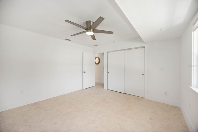 311 Island Cir, Sarasota, FL 34242 - unfurnished bedroom featuring a closet, a ceiling fan, and light colored carpet