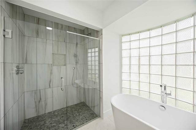 311 Island Cir, Sarasota, FL 34242 - bathroom featuring a stall shower, a freestanding tub, and tile patterned flooring