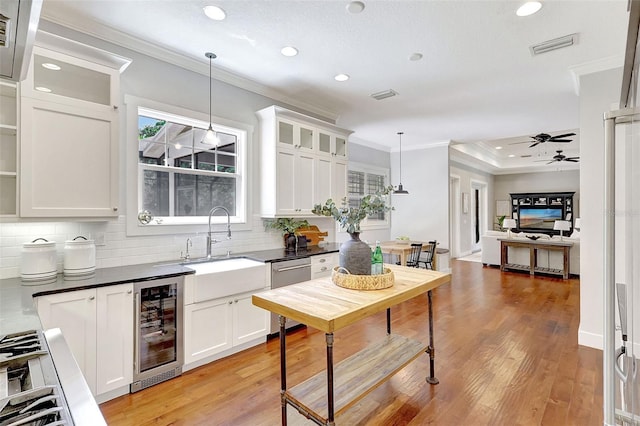 1906 143rd Ct E, Bradenton, FL 34212 - kitchen with beverage cooler, stainless steel appliances, crown molding, dark countertops, and decorative backsplash