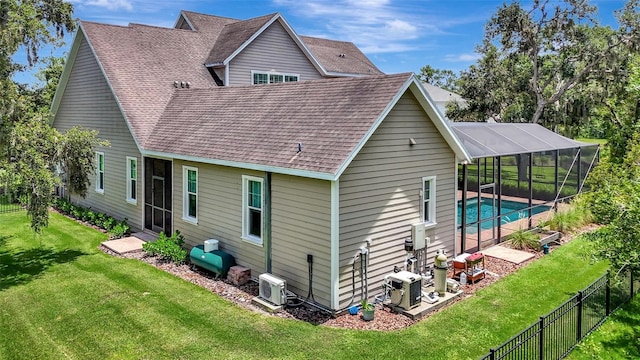 1906 143rd Ct E, Bradenton, FL 34212 - back of property with a fenced backyard, a shingled roof, and glass enclosure