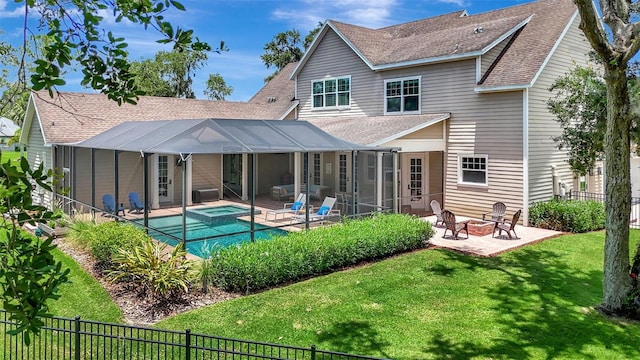 1906 143rd Ct E, Bradenton, FL 34212 - back of house featuring a patio, a shingled roof, an outdoor fire pit, a fenced backyard, and glass enclosure