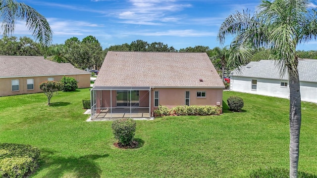 4539 Cabbage Key Ter, Bradenton, FL 34203 - rear view of house featuring a sunroom, a yard, stucco siding, and roof with shingles