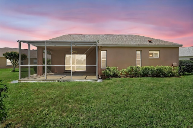 4539 Cabbage Key Ter, Bradenton, FL 34203 - rear view of house with stucco siding, a lawn, a patio, and glass enclosure