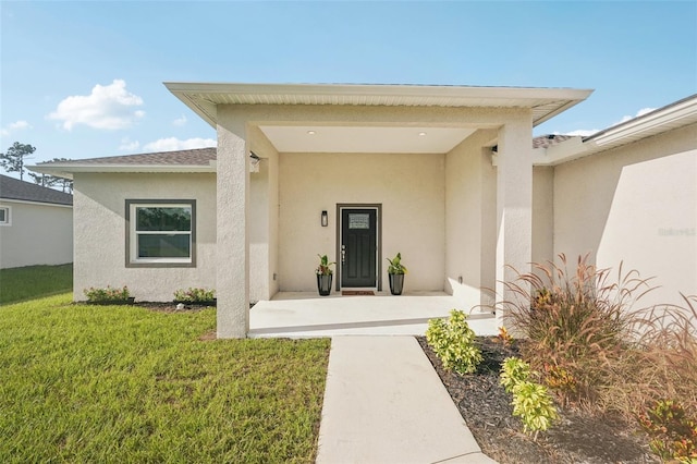 5534 Fairlane Dr, North Port, FL 34288 - view of exterior entry with stucco siding and a yard