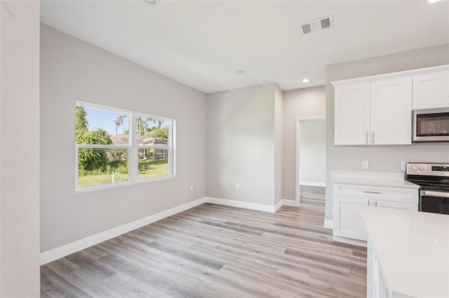 5534 Fairlane Dr, North Port, FL 34288 - kitchen featuring stainless steel appliances, light countertops, white cabinets, light wood-style floors, and recessed lighting
