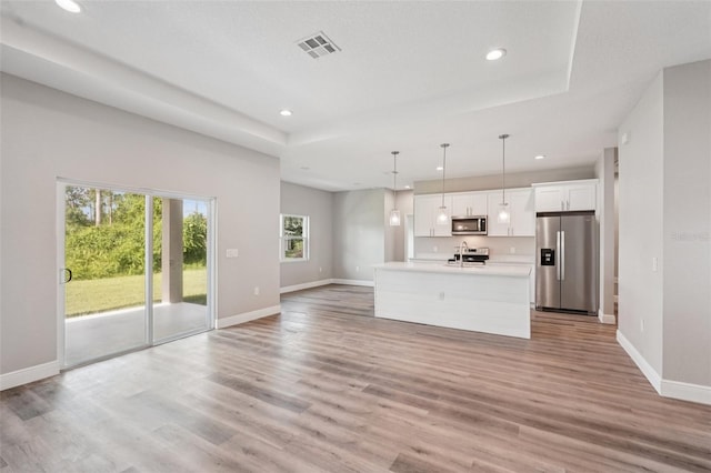5534 Fairlane Dr, North Port, FL 34288 - unfurnished living room with recessed lighting, light wood-style floors, and a raised ceiling