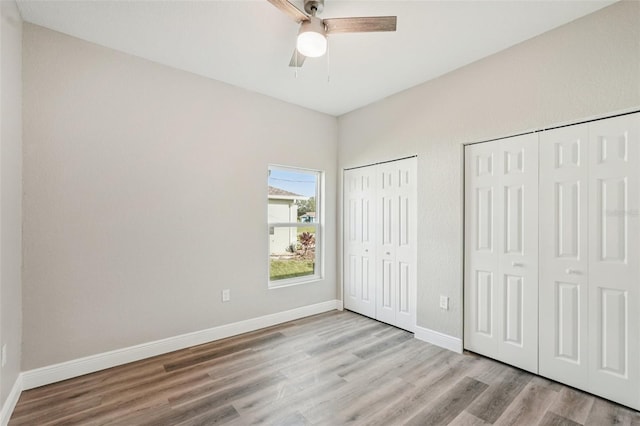5534 Fairlane Dr, North Port, FL 34288 - unfurnished bedroom featuring multiple closets, wood finished floors, and ceiling fan