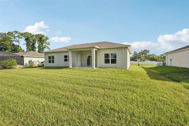 5534 Fairlane Dr, North Port, FL 34288 - rear view of property featuring stucco siding and a yard