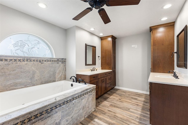 6118 56th Ter E, Bradenton, FL 34203 - bathroom with a ceiling fan, wood finished floors, two vanities, a bath, and recessed lighting