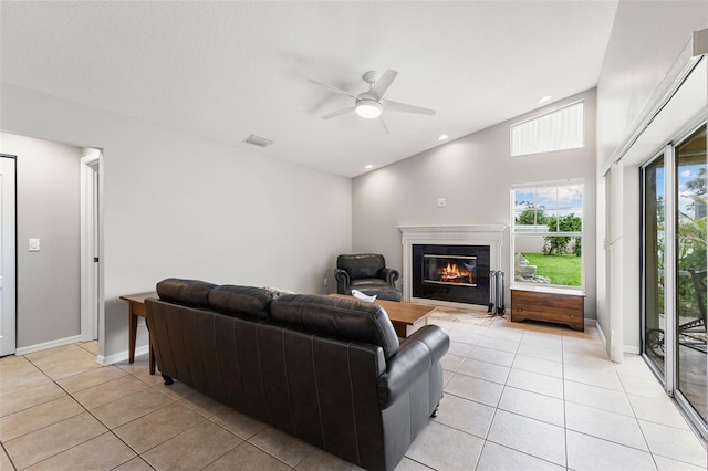 6118 56th Ter E, Bradenton, FL 34203 - living room with light tile patterned floors, a glass covered fireplace, and a ceiling fan