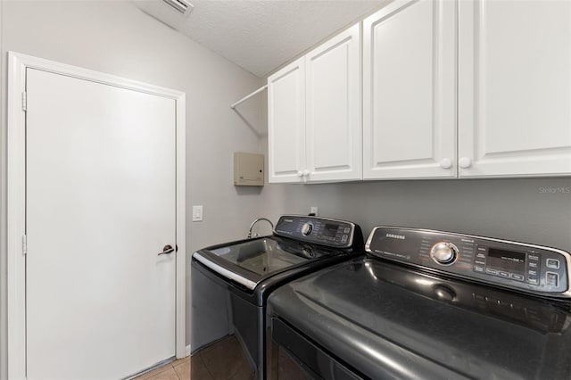 6118 56th Ter E, Bradenton, FL 34203 - laundry room featuring separate washer and dryer, cabinet space, light tile patterned flooring, and a textured ceiling