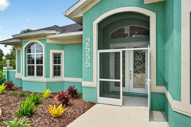 2555 Pear St, Port Charlotte, FL 33948 - property entrance with stucco siding, french doors, and a shingled roof