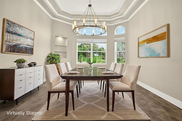 2555 Pear St, Port Charlotte, FL 33948 - dining space with crown molding, a tray ceiling, a chandelier, dark wood-style floors, and a towering ceiling