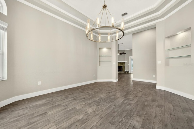 2555 Pear St, Port Charlotte, FL 33948 - empty room with a chandelier, ornamental molding, dark wood-style floors, a tray ceiling, and built in features