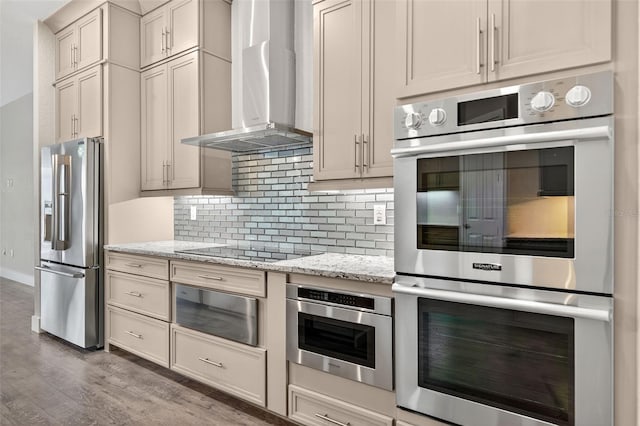 2555 Pear St, Port Charlotte, FL 33948 - kitchen with appliances with stainless steel finishes, wall chimney range hood, wood finished floors, backsplash, and light stone counters