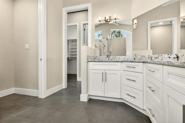 2555 Pear St, Port Charlotte, FL 33948 - bathroom featuring double vanity, a walk in closet, a shower, and tile patterned flooring