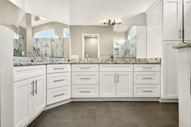 2555 Pear St, Port Charlotte, FL 33948 - full bathroom with a marble finish shower, double vanity, a chandelier, and tile patterned flooring