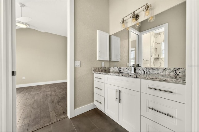 2555 Pear St, Port Charlotte, FL 33948 - bathroom with vanity, a textured wall, vaulted ceiling, tile patterned floors, and a shower