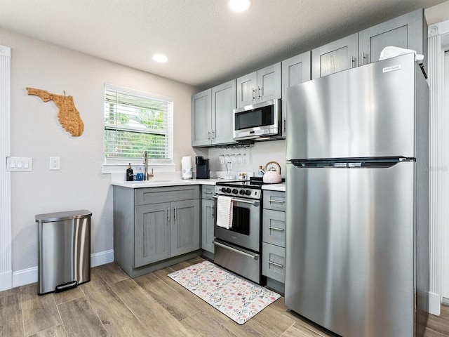 544 Canal Rd, Sarasota, FL 34242 - kitchen with appliances with stainless steel finishes, gray cabinets, light wood finished floors, light countertops, and recessed lighting