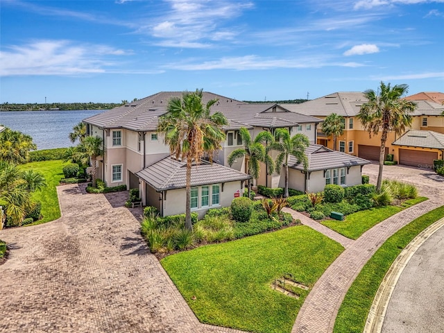 1226 Riverscape St, Bradenton, FL 34208 - view of front of house with decorative driveway, a water view, stucco siding, a tiled roof, and a residential view