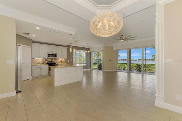 1226 Riverscape St, Bradenton, FL 34208 - kitchen featuring stainless steel appliances, open floor plan, ceiling fan, tasteful backsplash, and ornamental molding