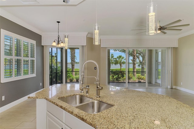 1226 Riverscape St, Bradenton, FL 34208 - kitchen with pendant lighting, a ceiling fan, crown molding, white cabinetry, and light stone countertops