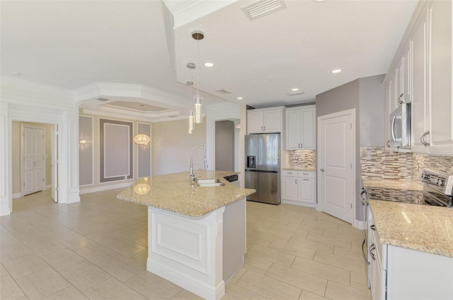 1226 Riverscape St, Bradenton, FL 34208 - kitchen featuring appliances with stainless steel finishes, decorative backsplash, white cabinets, a kitchen island with sink, and light stone counters