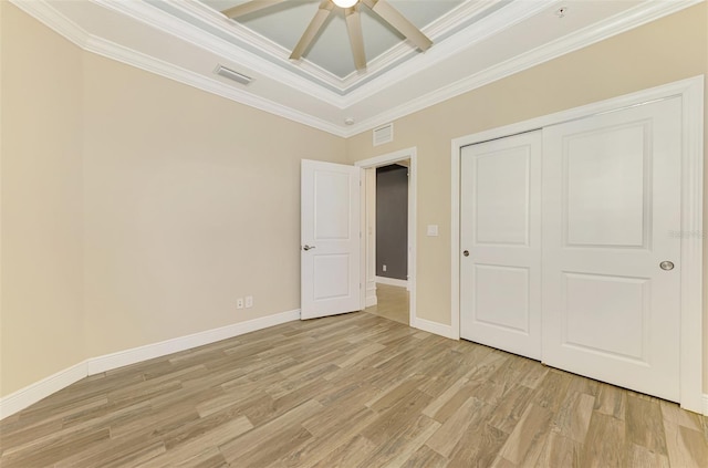 1226 Riverscape St, Bradenton, FL 34208 - unfurnished bedroom with light wood finished floors, ornamental molding, a closet, a ceiling fan, and a tray ceiling