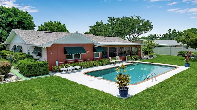 1907 76th St NW, Bradenton, FL 34209 - rear view of property with a fenced backyard, a patio, board and batten siding, a shingled roof, and a sunroom