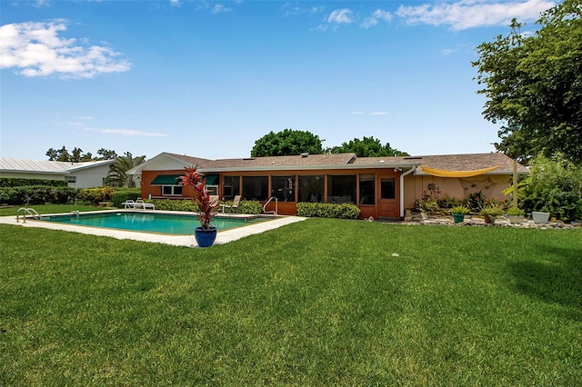 1907 76th St NW, Bradenton, FL 34209 - rear view of house with a sunroom, a lawn, and an outdoor pool