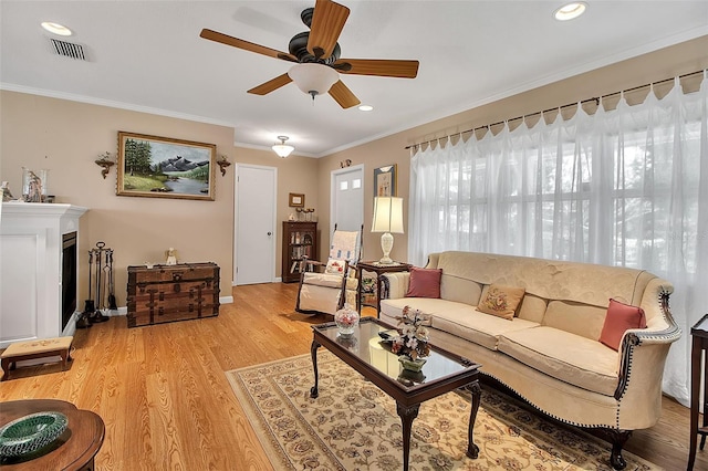 1907 76th St NW, Bradenton, FL 34209 - living area with a ceiling fan, light wood-style floors, ornamental molding, recessed lighting, and a fireplace