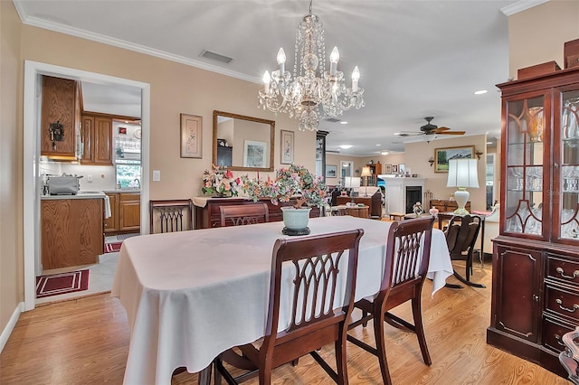 1907 76th St NW, Bradenton, FL 34209 - dining area featuring a ceiling fan, light wood-style flooring, a chandelier, crown molding, and recessed lighting