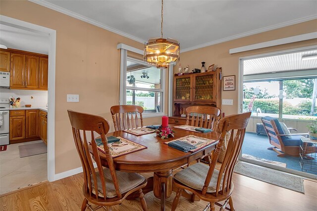 1907 76th St NW, Bradenton, FL 34209 - dining space with a chandelier, plenty of natural light, crown molding, and light wood-style floors