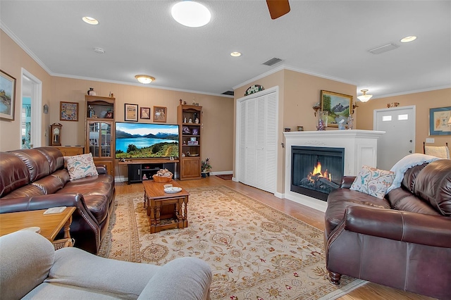1907 76th St NW, Bradenton, FL 34209 - living room with light wood-style flooring, a warm lit fireplace, ornamental molding, recessed lighting, and ceiling fan
