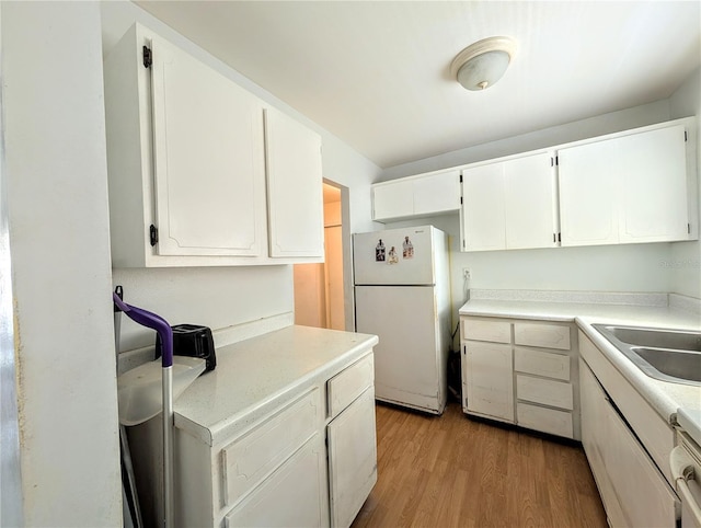 5948 Easy St Unit K35, Bradenton, FL 34207 - kitchen with freestanding refrigerator, light wood finished floors, white cabinets, and light countertops