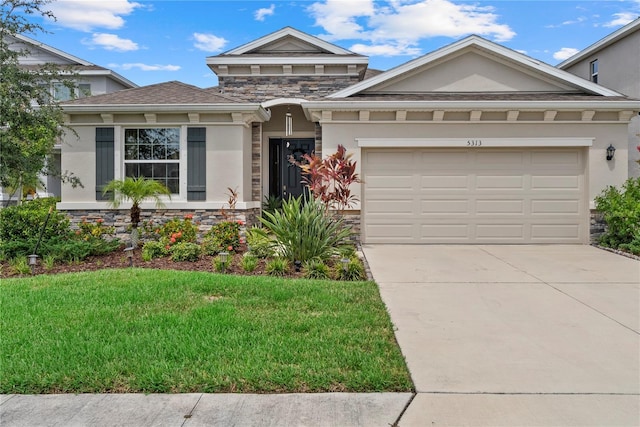 5313 Halewood Ct, Lakewood Ranch, FL 34211 - view of front facade featuring stone siding, concrete driveway, a front lawn, a garage, and stucco siding