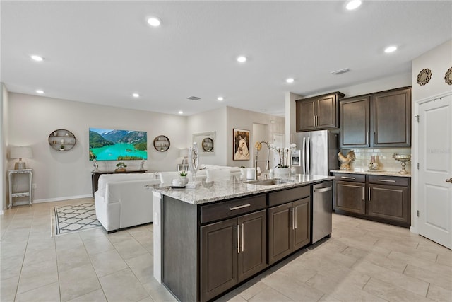5313 Halewood Ct, Lakewood Ranch, FL 34211 - kitchen with stainless steel appliances, dark brown cabinets, open floor plan, light stone countertops, and recessed lighting