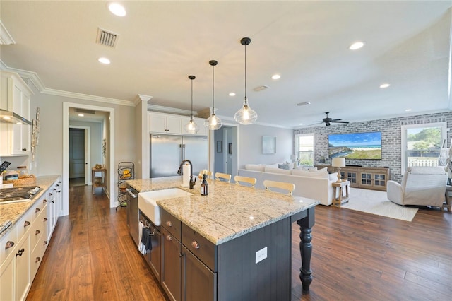 636 Meadow Lake Dr, Freeport, FL 32439 - kitchen with appliances with stainless steel finishes, open floor plan, a kitchen bar, dark wood-type flooring, and ornamental molding