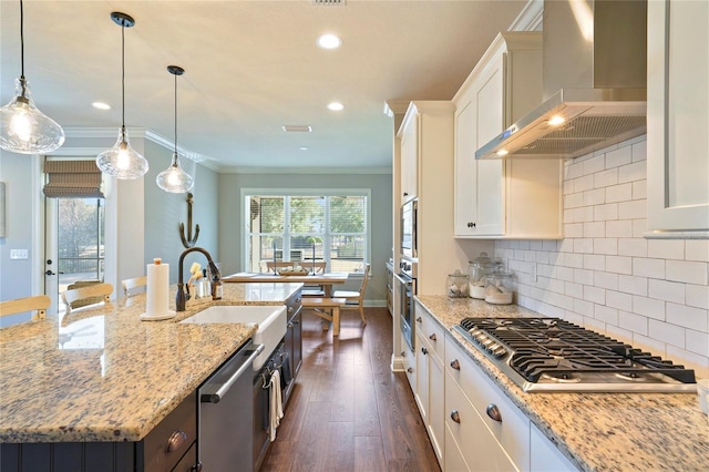 636 Meadow Lake Dr, Freeport, FL 32439 - kitchen with appliances with stainless steel finishes, wall chimney range hood, white cabinetry, a center island with sink, and dark wood finished floors