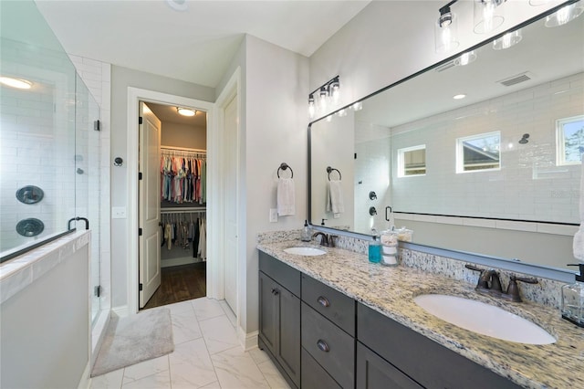 636 Meadow Lake Dr, Freeport, FL 32439 - bathroom featuring a stall shower, double vanity, marble finish flooring, and a spacious closet