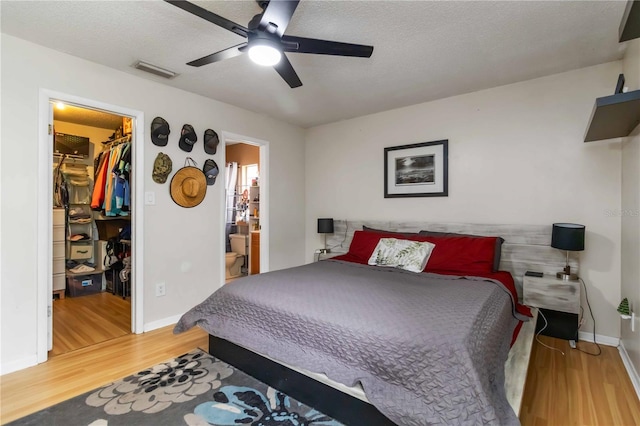 616 Bryan Terrace Dr, Brandon, FL 33511 - bedroom with a walk in closet, wood finished floors, a closet, ensuite bathroom, and a ceiling fan