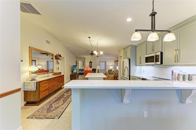 133 Tucker Ave, Sarasota, FL 34232 - kitchen featuring white microwave, high end refrigerator, open floor plan, light countertops, and a breakfast bar