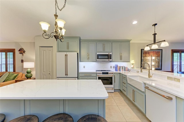 133 Tucker Ave, Sarasota, FL 34232 - kitchen with white appliances, light stone countertops, a chandelier, light tile patterned flooring, and decorative light fixtures