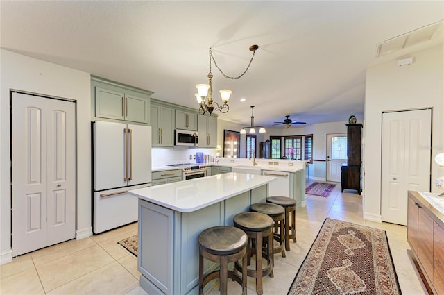 133 Tucker Ave, Sarasota, FL 34232 - kitchen with white appliances, a peninsula, a chandelier, a center island, and light tile patterned flooring