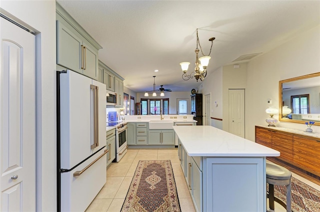 133 Tucker Ave, Sarasota, FL 34232 - kitchen featuring white appliances, a peninsula, a chandelier, light countertops, and light tile patterned flooring