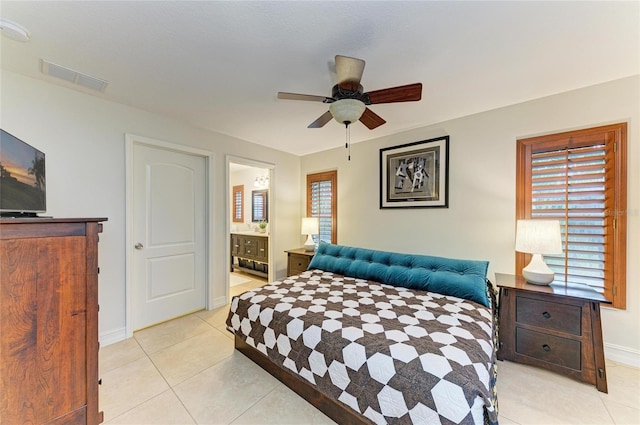 133 Tucker Ave, Sarasota, FL 34232 - bedroom with multiple windows, light tile patterned floors, connected bathroom, and ceiling fan