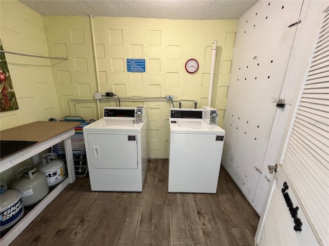 611 Gulf Dr N Unit B24, Bradenton Beach, FL 34217 - community laundry room featuring dark wood-style floors, washing machine and clothes dryer, concrete block wall, and a textured ceiling