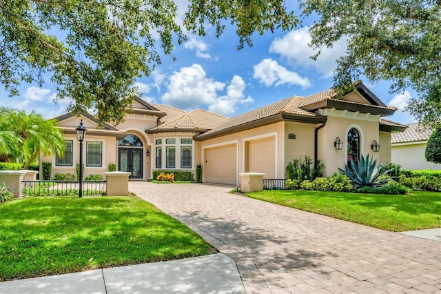 14611 Leopard Creek Pl, Lakewood Ranch, FL 34202 - mediterranean / spanish-style home featuring an attached garage, a front lawn, stucco siding, decorative driveway, and a tiled roof