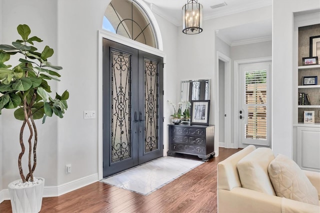 14611 Leopard Creek Pl, Lakewood Ranch, FL 34202 - entryway with wood finished floors, crown molding, a chandelier, and french doors