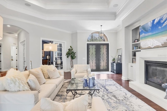 14611 Leopard Creek Pl, Lakewood Ranch, FL 34202 - living room with french doors, a raised ceiling, arched walkways, dark wood finished floors, and crown molding